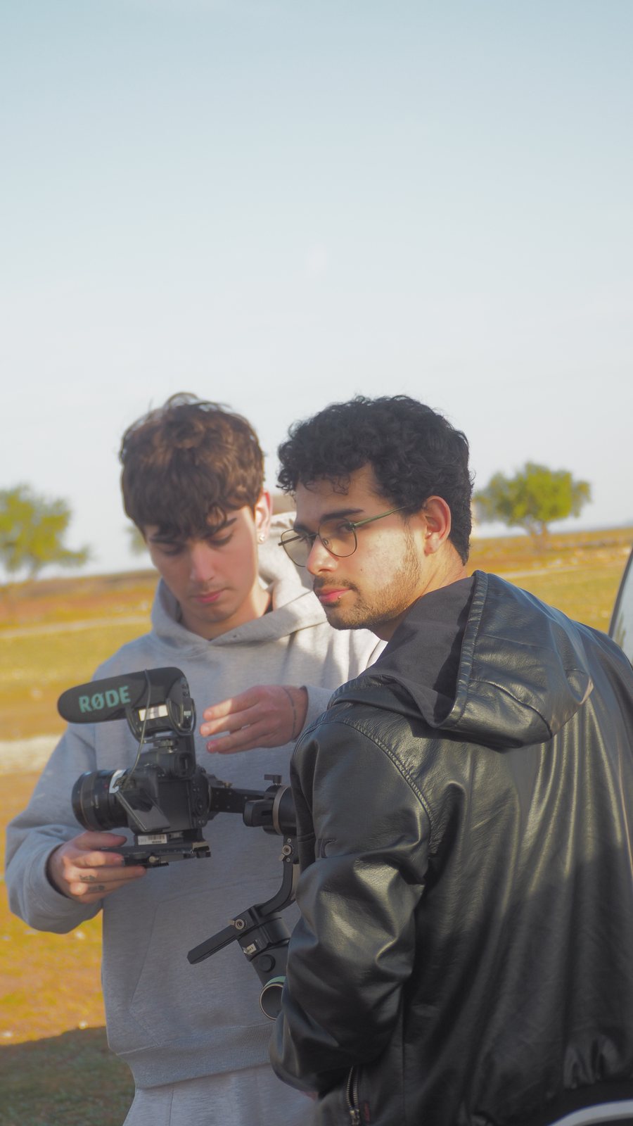 Camera operator filming a person outdoors
